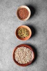 Pumpkin, linseed and sunflower seeds in bowls viewed above