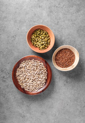 Pumpkin, linseed and sunflower seeds in bowls viewed above