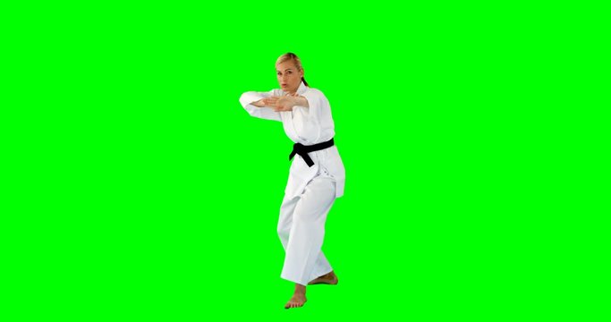 Woman doing judo on a green background