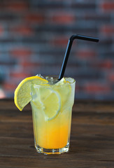Lemonade with lemon and syrup on a wooden table. Summer drink.