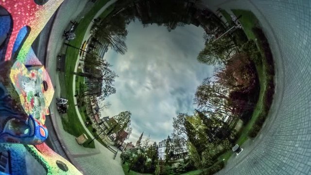 People Walk by Footpath Park Alley Video 360 vr Panoramic View of Square Sculpture is in the Middle of the Park Paving Stones Green Lawns Opole Poland