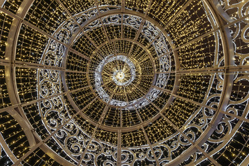 Garland coiled on a large steel frame, simulates a festive Christmas tree. View from inside the...