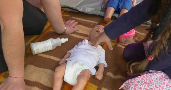 the Little Girl is Practiced to do Indirect Massage of Heart to a Dummy