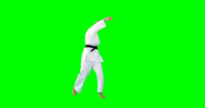 Front view of sportswoman is practising martial art against a green screen 