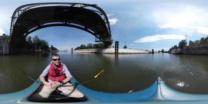 360Vr Video Man Kayaking Passing by Under Bridge by River Sunny Summer Day Man Has Sports at the Nature Rowing With Two-Sided Oar Green Trees Horizon