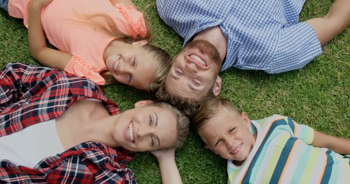 Happy family lying together in the garden 
