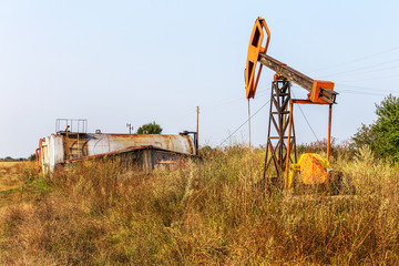 A small private oil derrick pumps oil on the field. 