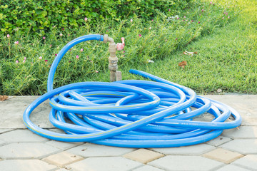 water tap with blue rubber tube on park