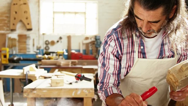 Carpenter using hammer and chisel 
