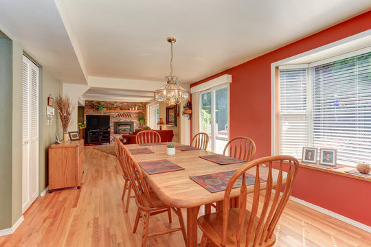 Red dining room interior with large wooden table and chairs
