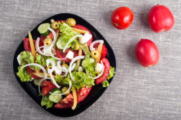Top view of a small bowl of salad from natural raw vegetables