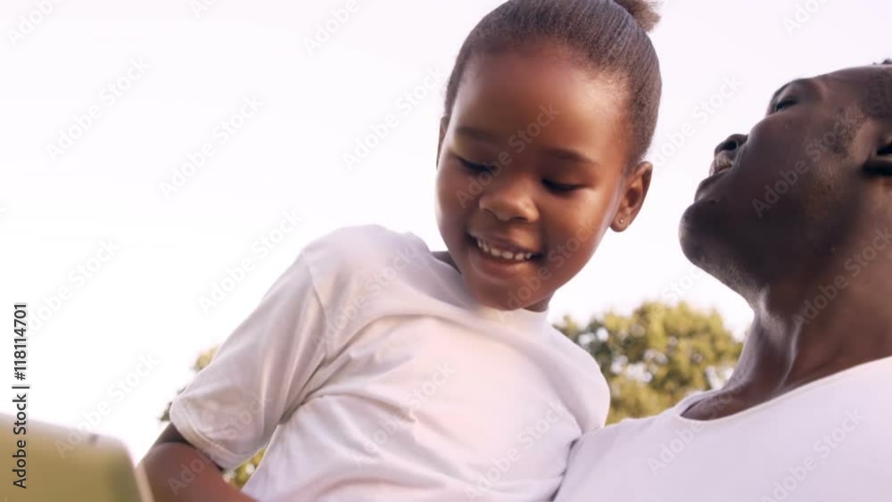Poster portrait of father is using a tablet with his daughter