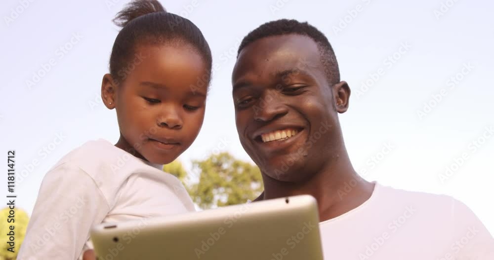 Poster man looking a tablet computer with his daughter