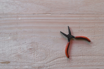 The old rusty plier on wooden background