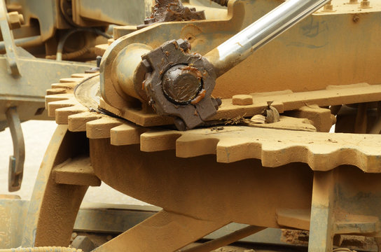close up of large grader gear and grease on join hydrolic lifter