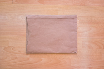 Old brown envelope on wooden table floor background