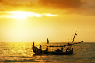 Fisherman paddle boat in sunset