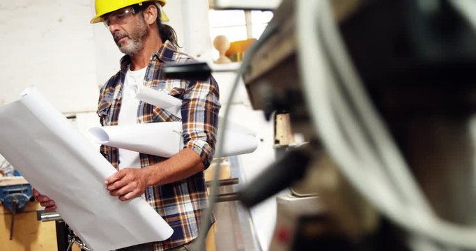Serious carpenter reading plan with hard hat