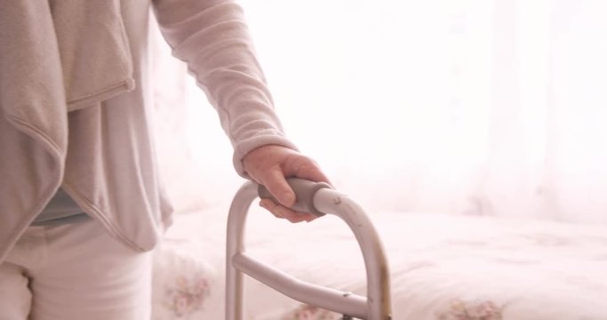 Female doctor assisting a senior woman to walk