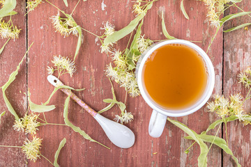 Linden tea in a cup on a wooden background.
