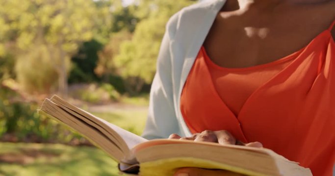 Focus of woman is reading a book in a park