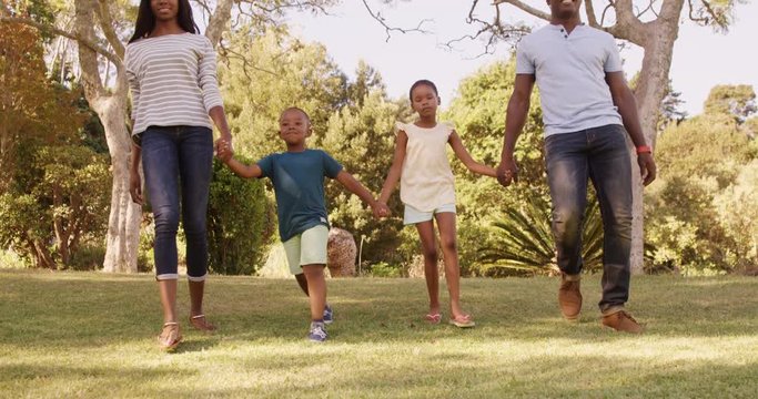 Low angle view of happy family holding hands and walking