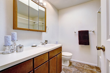 White bathroom with brown cabinets in old American house