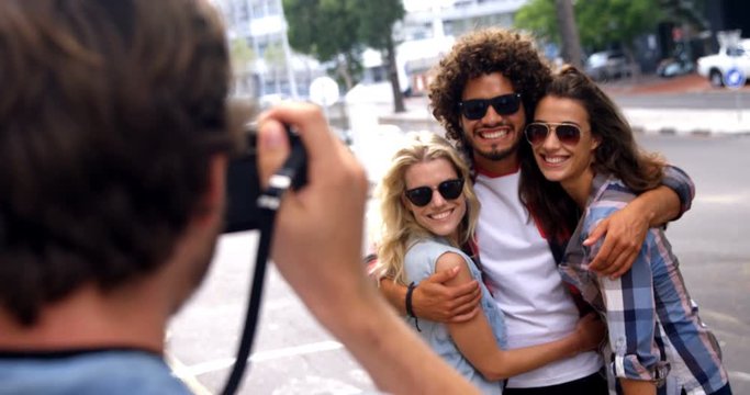 Young man photographing his friends with a camera