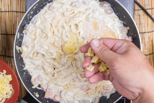 Spaghetti putting mozzarella cheese to the pan