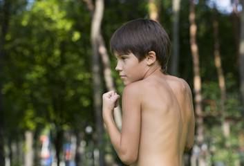 Fototapeta na wymiar portrait of a boy in nature which shows his muscles