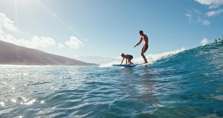 Father and son having fun surfing together, summer lifestyle family time - Powered by Adobe