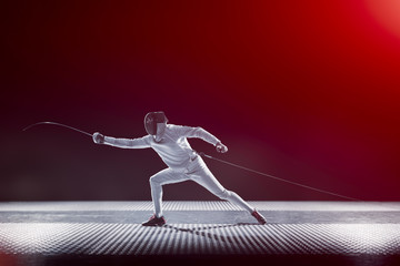 Fencing player isolated on black red gradient background