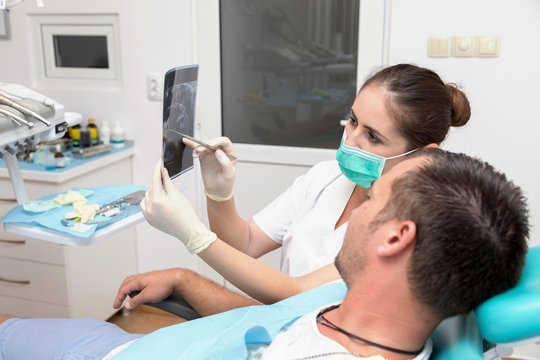 Image of young patient and dentist showing him x-ray radiography, in the Dental Clinc