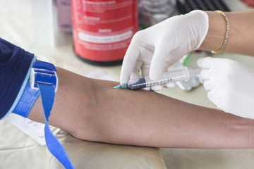 A nurse draw blood to check for diseases.
