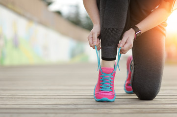Woman runner tying laces before training. Marathon.