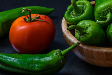tomato and chili pepper on a dark background