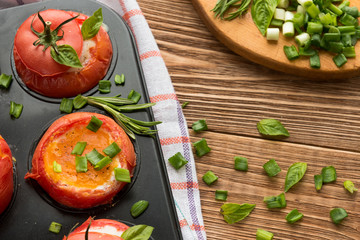 Eggs with rosemary and basil baked in tomato, top view.
