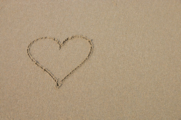 A heart symbol on the sandy beach.