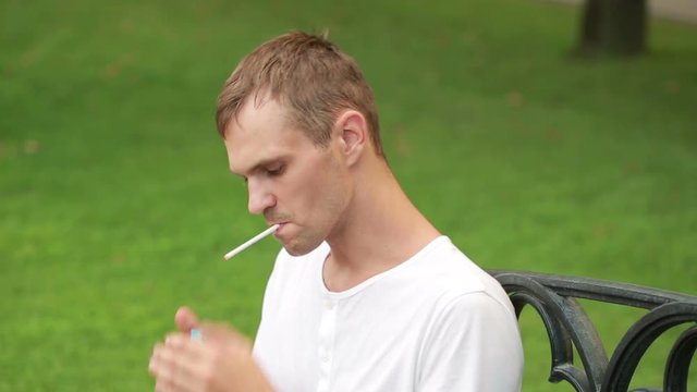 Man smoking thin cigarette at the park