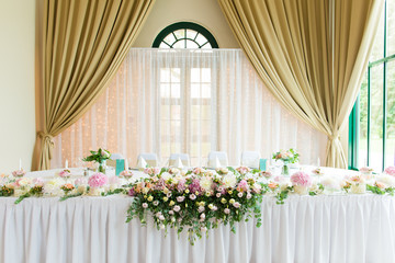 Fototapeta na wymiar Indoors wedding reception venue with décor, selective focus on flowers