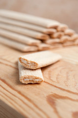 Biscuit sticks with filling on a wooden surface