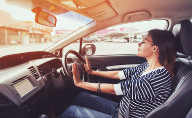 Asian woman driving a car.