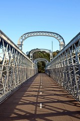 Fototapeta premium Walkway over an arched bridge that spans the Woronora River, Sutherland Shire, New South Wales, Australia