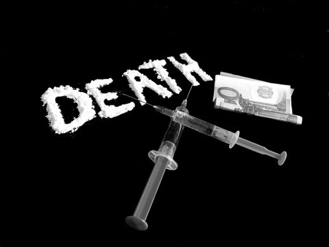 Cocaine drug powder in shaped death word, two crossed injections and hundred euro banknote on black background in black and white colors