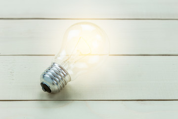 Bulb with lighting on wood background.