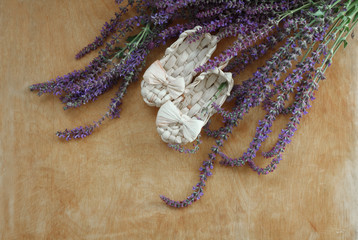 bast shoes on wooden background with sage flowers