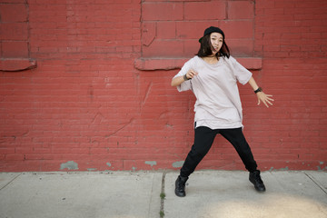 Young Asian woman in city dancing hip hop