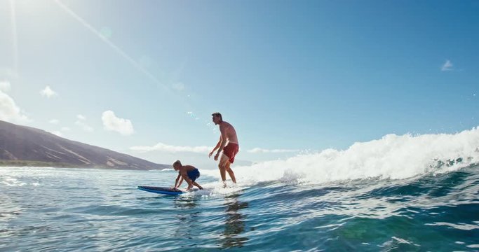 Father and son having fun surfing together, summer lifestyle family time