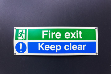 fire exit sign on black wall