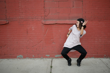 Young Asian woman dancing hip hop in city